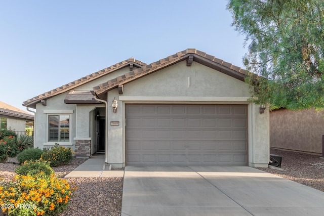 view of front of property featuring stucco siding, an attached garage, concrete driveway, and a tile roof