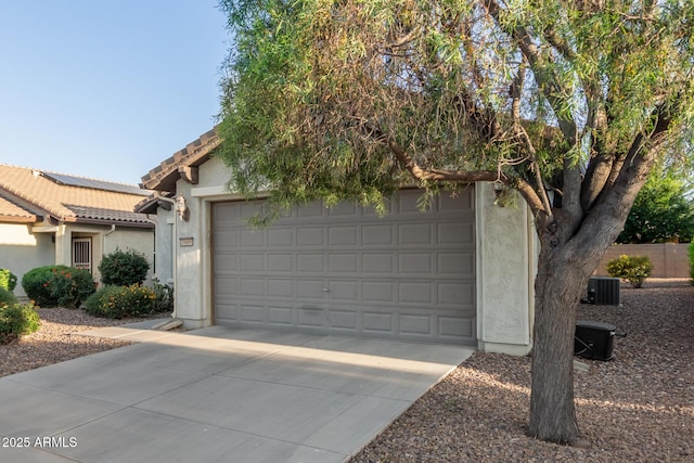 garage featuring central air condition unit and driveway