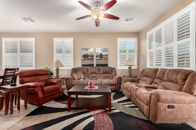 living area featuring ceiling fan and visible vents