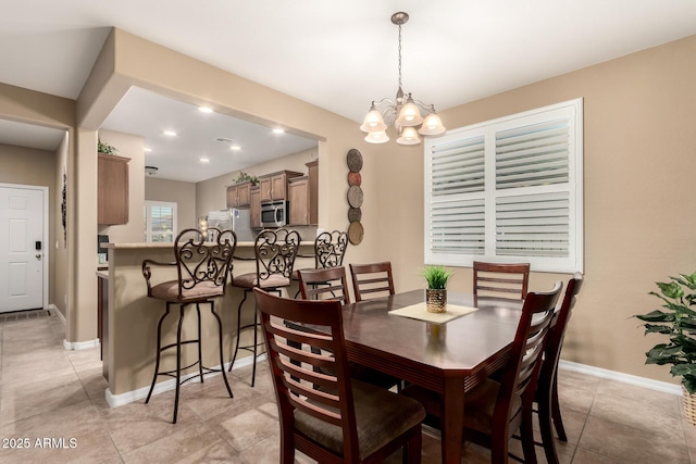dining space with recessed lighting, baseboards, a notable chandelier, and light tile patterned floors