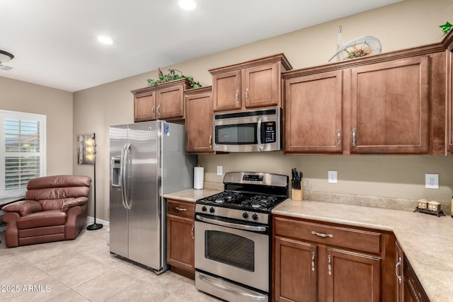kitchen featuring visible vents, appliances with stainless steel finishes, brown cabinets, light countertops, and light tile patterned floors
