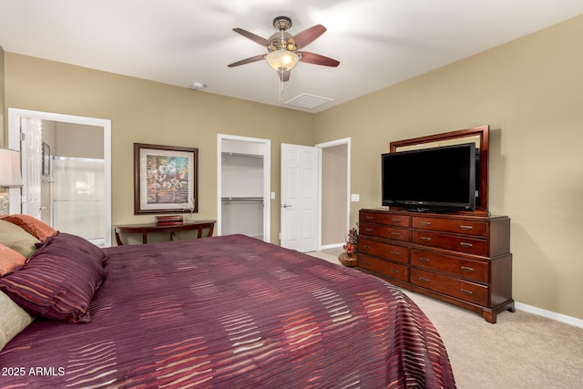 bedroom with baseboards, visible vents, a spacious closet, light colored carpet, and ceiling fan