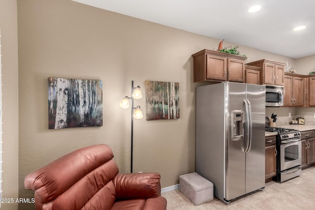 kitchen featuring open floor plan, baseboards, recessed lighting, appliances with stainless steel finishes, and light tile patterned floors