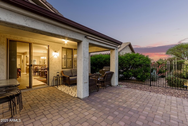 patio terrace at dusk with fence and outdoor lounge area