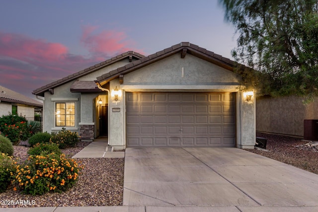 single story home featuring a garage, a tile roof, concrete driveway, and stucco siding