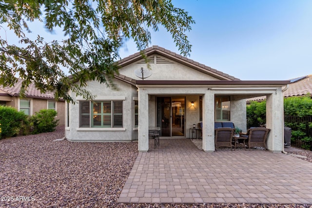 back of property with a patio and stucco siding