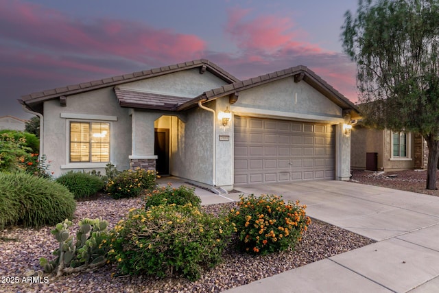 ranch-style home featuring stucco siding, a tiled roof, driveway, and a garage