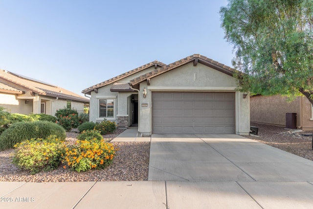 view of front of property featuring a tile roof, an attached garage, driveway, and stucco siding