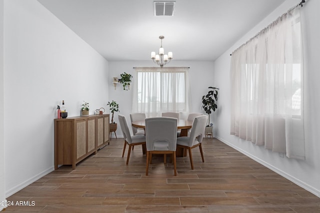 dining room featuring dark wood-type flooring and a chandelier