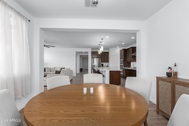 dining space featuring ceiling fan and sink