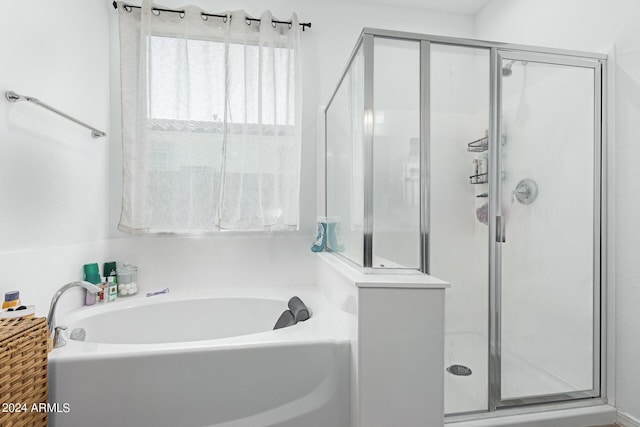 bathroom featuring separate shower and tub