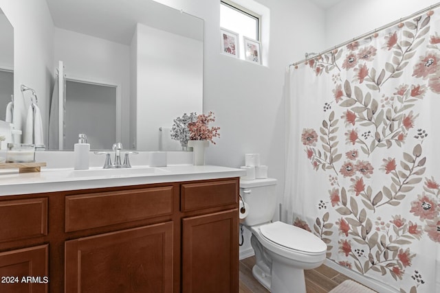 bathroom with vanity, a shower with shower curtain, and toilet