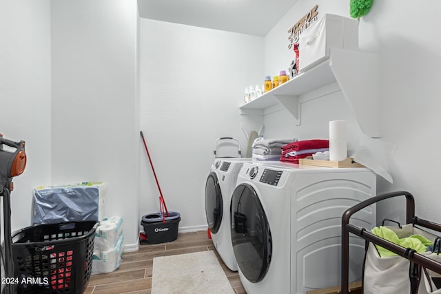 laundry room with light wood-type flooring and washing machine and clothes dryer