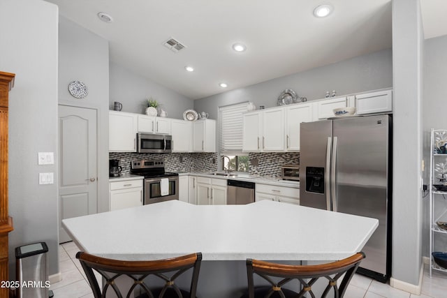 17611 W Ingleside Dr, Surprise, AZ 85374 - kitchen featuring tasteful backsplash, stainless steel appliances, light tile patterned floors, visible vents, and lofted ceiling