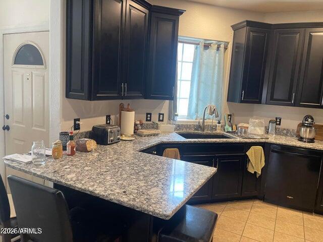 22744 E Carla Vista Dr, Mesa, AZ 85212 - kitchen featuring light tile patterned floors, a sink, a breakfast bar, black dishwasher, and a peninsula