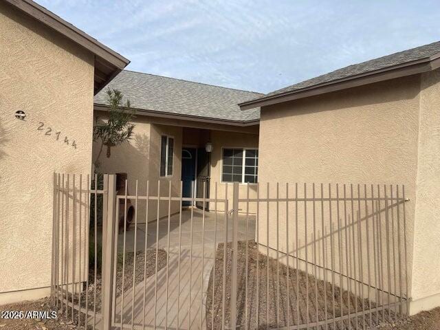 22744 E Carla Vista Dr, Mesa, AZ 85212 - view of exterior entry featuring a gate, fence, stucco siding, and roof with shingles
