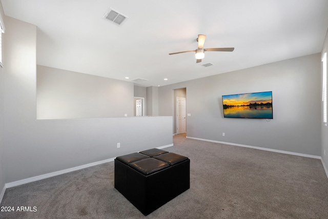 living area with ceiling fan and carpet