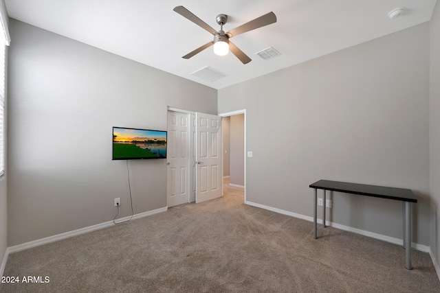 unfurnished bedroom with ceiling fan and light colored carpet