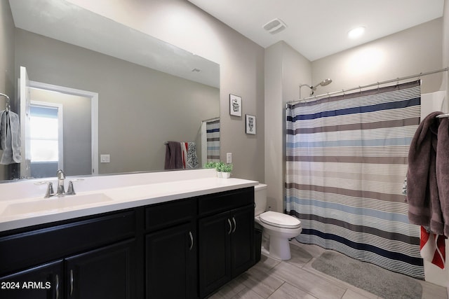 bathroom with a shower with shower curtain, vanity, and toilet