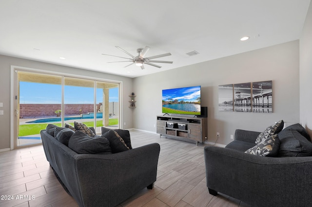 living room with ceiling fan and light hardwood / wood-style flooring