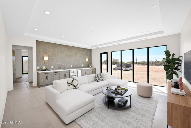 living area featuring a tray ceiling, light tile patterned flooring, recessed lighting, and baseboards