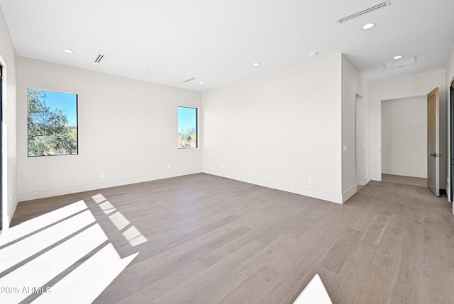 unfurnished room featuring light wood-type flooring, visible vents, baseboards, and recessed lighting