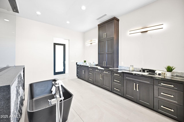 full bathroom featuring a soaking tub, recessed lighting, visible vents, and double vanity