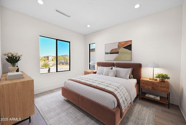 bedroom with light wood-style floors, recessed lighting, visible vents, and baseboards