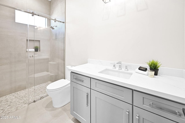 bathroom with tile patterned floors, vanity, toilet, and a shower stall