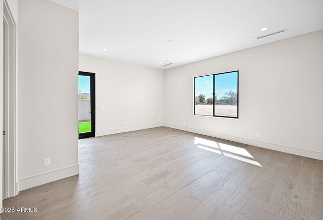 unfurnished room featuring recessed lighting, light wood-type flooring, plenty of natural light, and baseboards