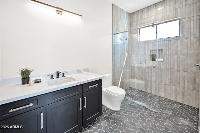 bathroom with tiled shower, toilet, vanity, and tile patterned flooring