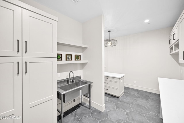 interior space with a sink, baseboards, and recessed lighting