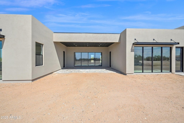 back of property with a patio area and stucco siding