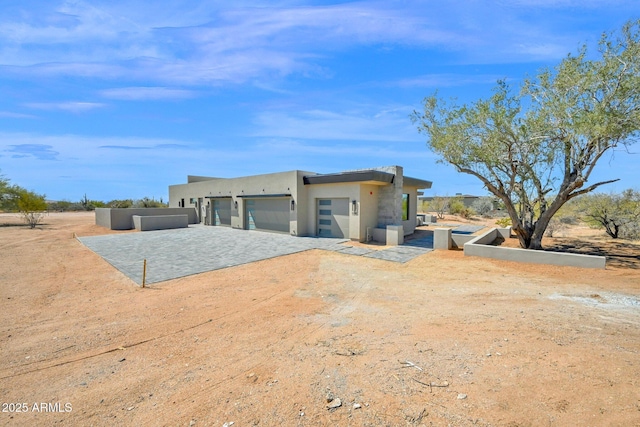 view of front of house with stucco siding, driveway, and a garage