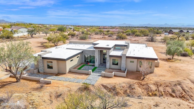 view of front facade with stucco siding, a mountain view, and a desert view