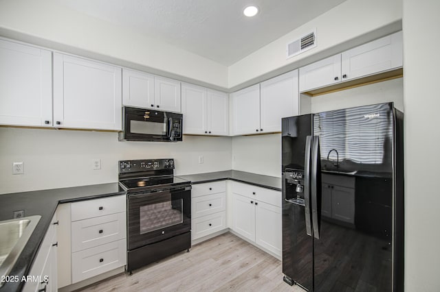 615 E Portland St Unit 261, Phoenix, AZ 85004 - kitchen with black appliances, light wood-style floors, white cabinets, dark countertops, and recessed lighting