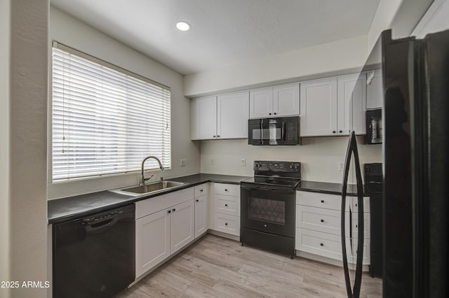 615 E Portland St Unit 261, Phoenix, AZ 85004 - kitchen featuring black appliances, dark countertops, white cabinetry, light wood-style flooring, and recessed lighting
