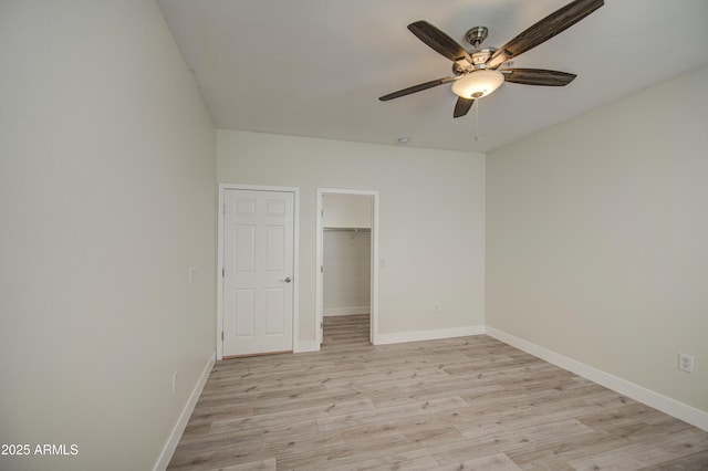 615 E Portland St Unit 261, Phoenix, AZ 85004 - unfurnished bedroom with light wood finished floors, a spacious closet, ceiling fan, and a closet