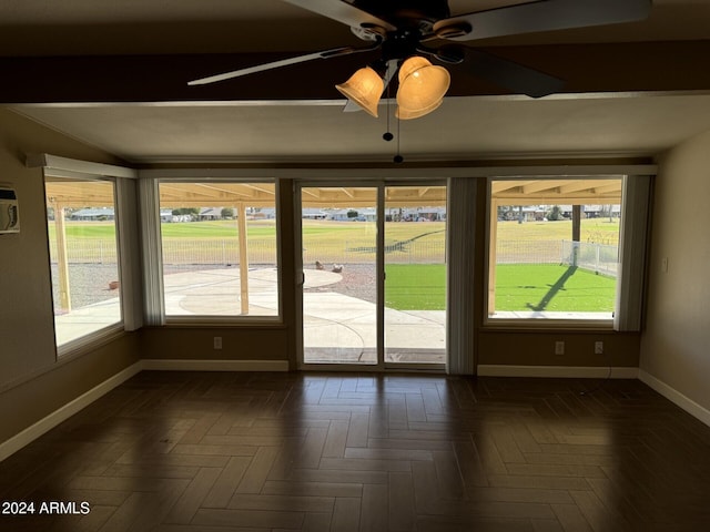 interior space featuring dark parquet floors, ceiling fan, and a healthy amount of sunlight