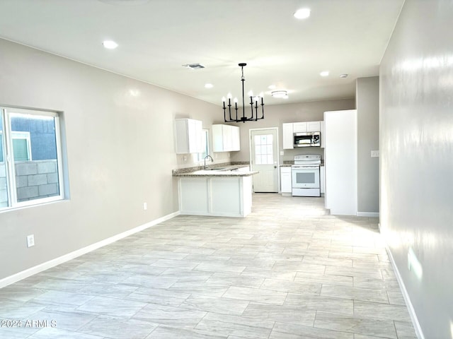 kitchen featuring plenty of natural light, white cabinetry, electric stove, and sink