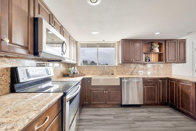 kitchen featuring decorative backsplash, stainless steel appliances, a textured ceiling, open shelves, and a sink