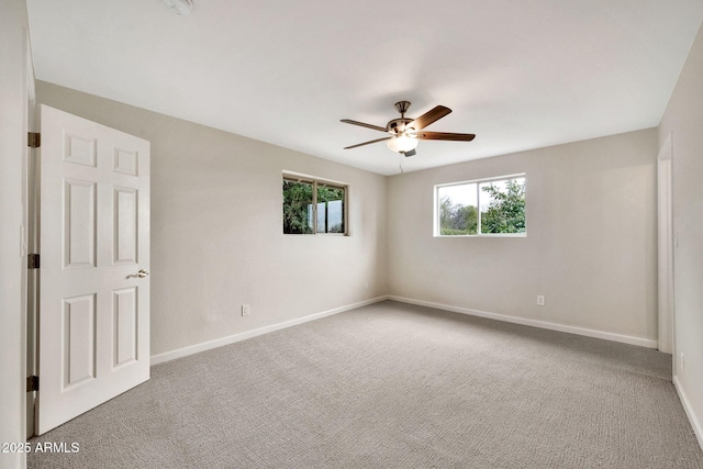 unfurnished room featuring carpet floors, baseboards, and a ceiling fan