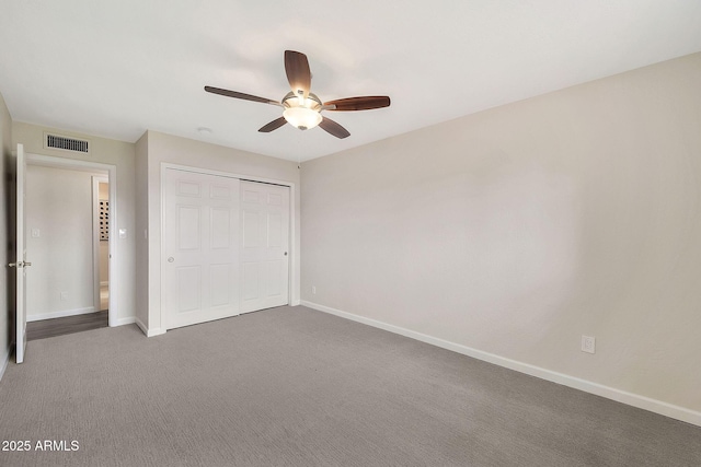 unfurnished bedroom with carpet floors, a closet, visible vents, and baseboards