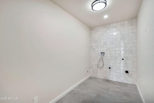 full bathroom featuring baseboards and a tile shower