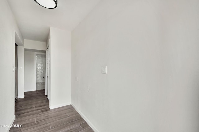 hallway featuring wood tiled floor and baseboards