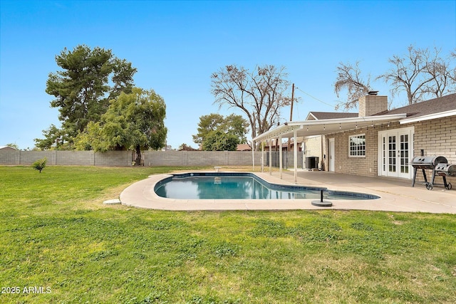 view of pool featuring a fenced in pool, french doors, a patio, a lawn, and a fenced backyard