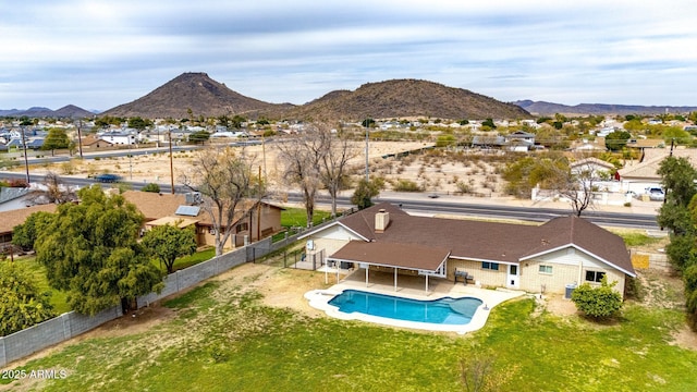 exterior space featuring a fenced in pool, a fenced backyard, a mountain view, and a patio