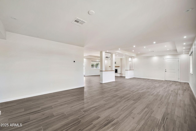 unfurnished living room featuring baseboards, visible vents, wood finished floors, and recessed lighting