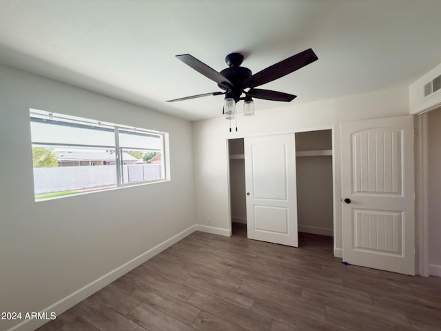 unfurnished bedroom featuring a closet, ceiling fan, and dark wood-type flooring