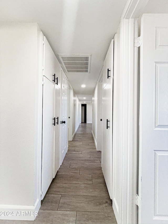 corridor with hardwood / wood-style flooring